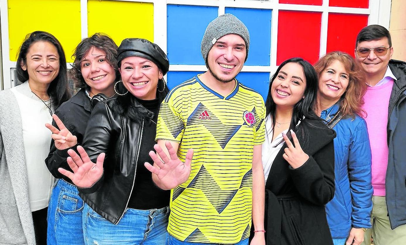 Un grupo de colombianos residentes en Gijón, frente a los colores de la bandera de su país.