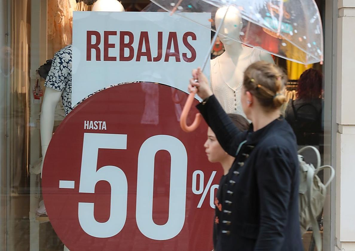 Una mujer pasa ante un escaparate de una tienda en rebajas en Asturias.