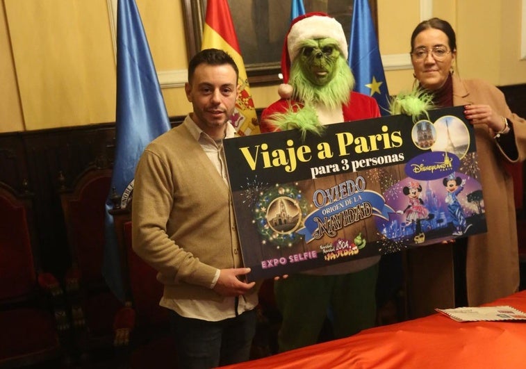 David Famos, el Grinch y Covadonga Díaz, con el premio del sorteo de Navidad en Oviedo.