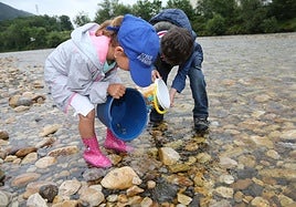 Dos niños juegan en el río Sella