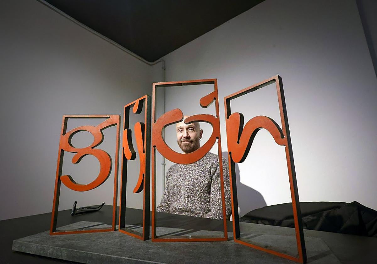 El diseñador gráfico Juan Jareño, en su estudio, con la maqueta original de la escultura de las 'Letronas' de Gijón.