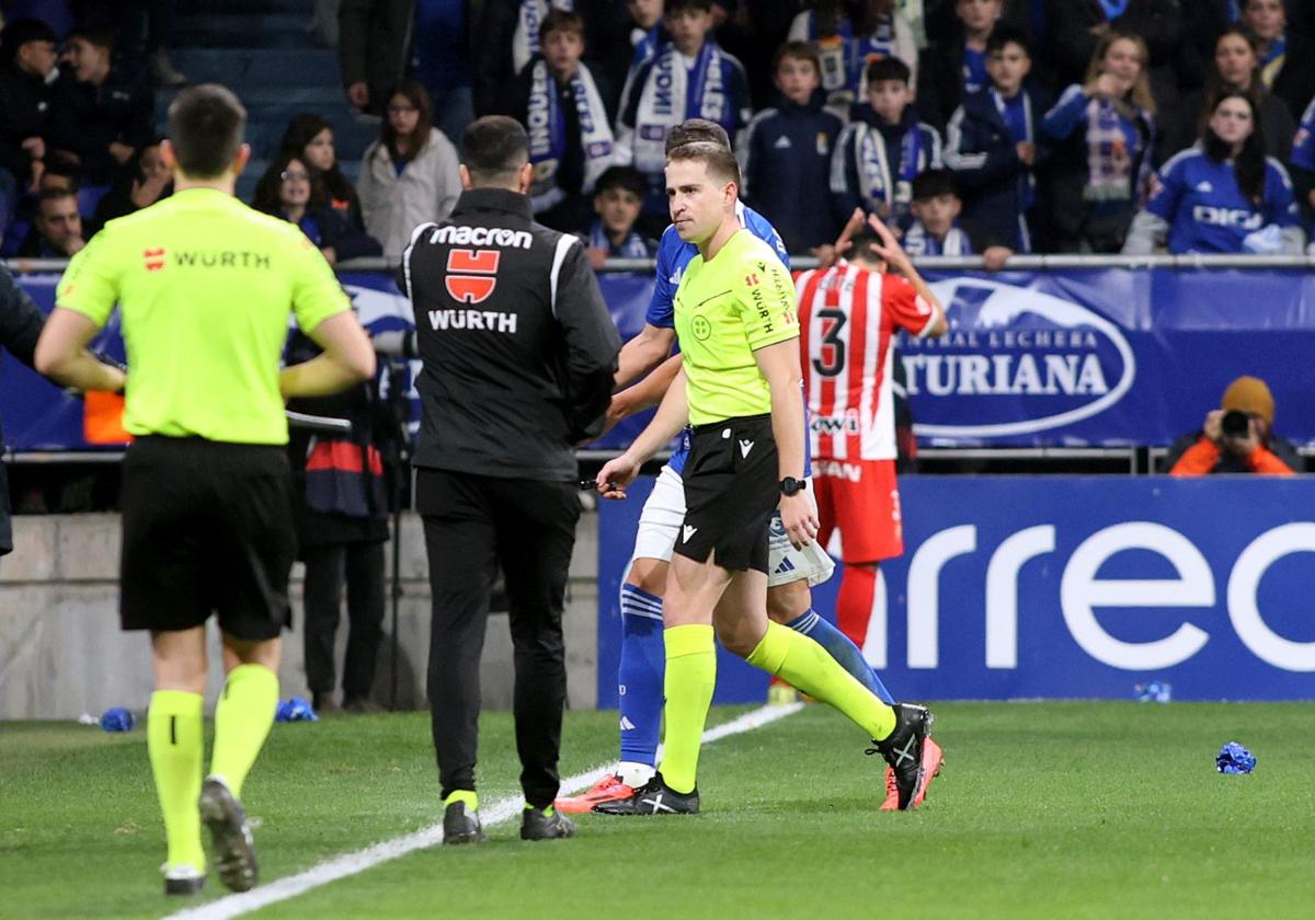 El colegiado del derbi asturiano, Sesma Espinosa, abandona el terreno de juego tras la decisión de paralizar el encuentro.