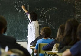 Una docente imparte clase en un aula.