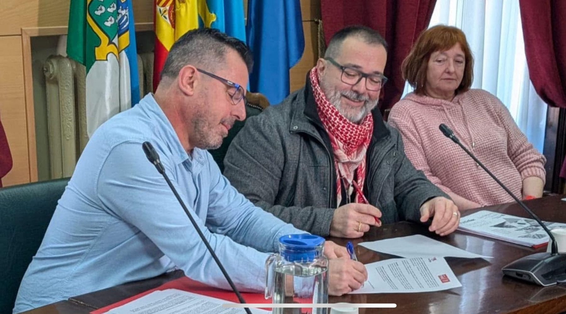 El alcalde Roberto García (IU) sonríe ante el portavoz socialista Javier Castro, que firma los presupuestos