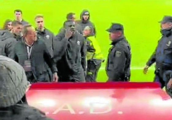 El jugador, junto a agentes de la Policía, se dirige al aficionado que le insultó y que fue expulsado, posteriormente, por el Sporting.