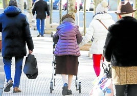 Personas mayores pasean por la calle.