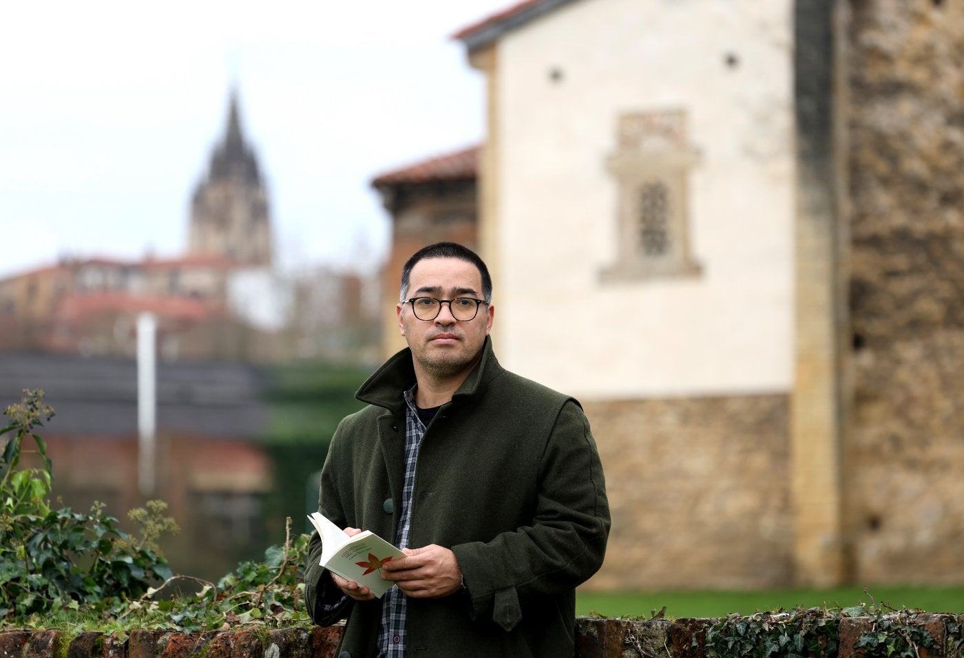 El escritor, en el entorno de la iglesiaprerrománica de Santullano, en Oviedo,con su libro.