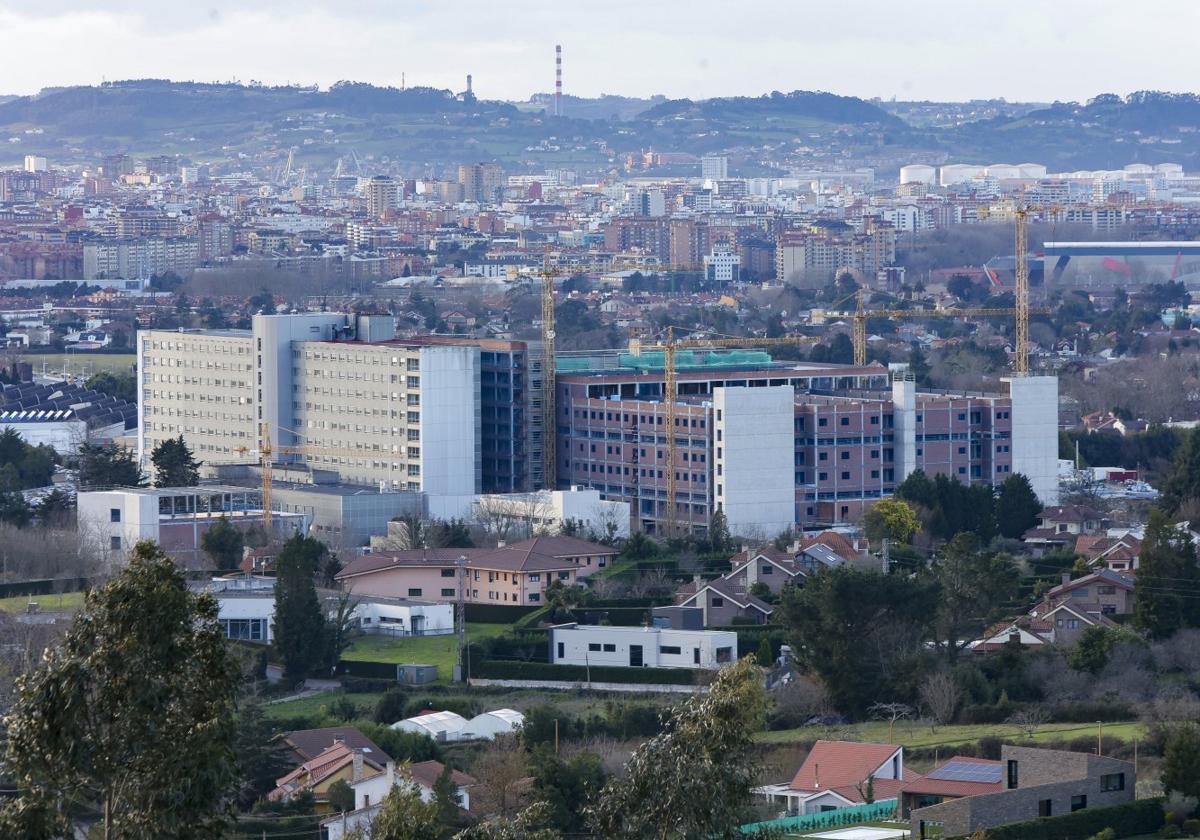 Vista general del Hospital Universitario de Cabueñes, con el edificio de hospitalización a la izquierda y las obras del nuevo bloque de la ampliación a la derecha.