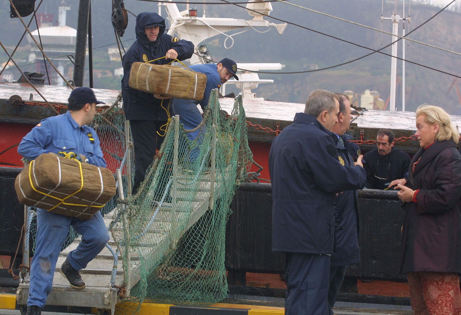 Efectivos de la Policía Nacional descargando la cocaína del barco Romios al tiempo que Mercedes Fernández, quien fuera delegada del Gobierno en Asturias, tomaba conocimiento de los detalles de la operación.