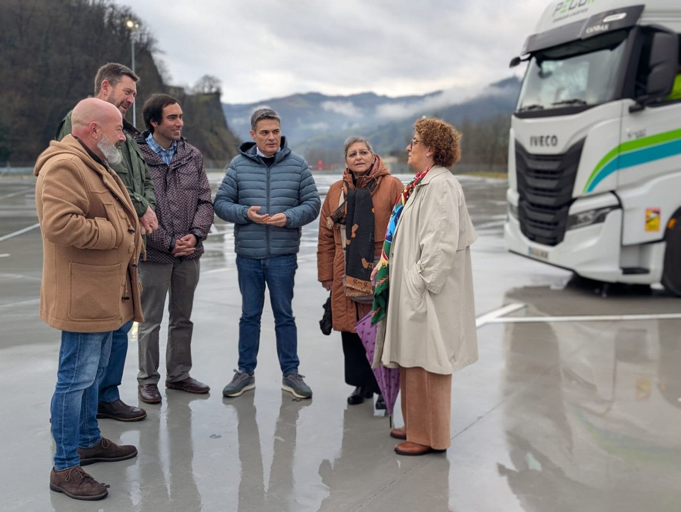 El diputado popular Pedro Rueda (centro) y la parlamentaria Gloria García (derecha), con la junta local del Partido Popular de Lena en el aparcamiento invernal.