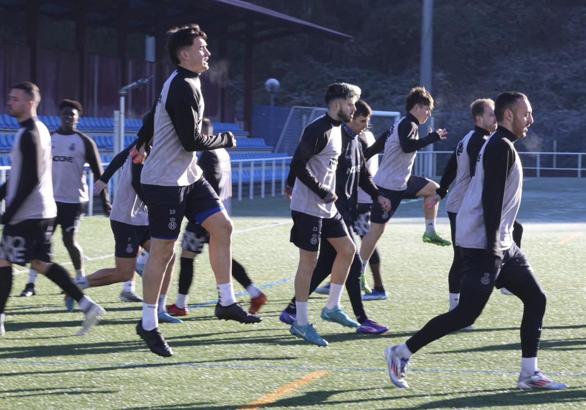 Los jugadores del Real Avilés, durante el calentamiento de un entrenamiento en el sintético de La Toba 2.