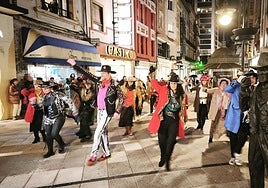Los participantes, bailando junto a la estatua de Tino Casal en la calle Palacio Valdés de Oviedo.