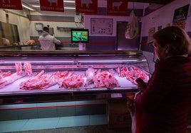Una mujer haciendo la compra en una carnicería.