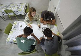 Una educadora social ejerce parte de sus labores en un centro de menores, con tres jóvenes.