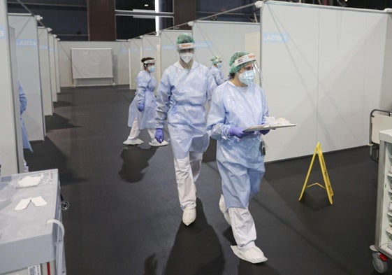 H144. Tres sanitarios se dirigen a atender a un paciente de los 355 que llegaron a pasar por las instalaciones del Hospital de la Feria de Gijón.