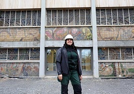 La restauradora, Rosana García Álvarez, frente a la fachada principal del Palacio de Deportes de Oviedo con los murales y vidrieras a su espalda.