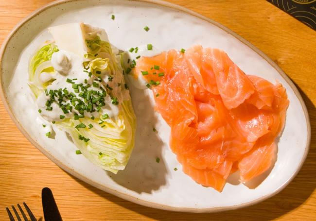 Lechuga con aderezo de queso azul y lonchas de salmón ahumado.