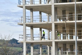 Dos trabajadores, en el interior de un edificio en construcción.