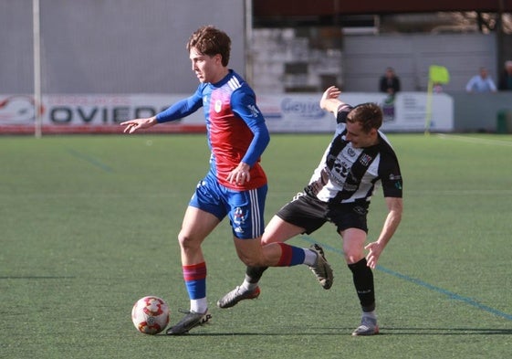 Liam López, jugador del Langreo, intenta escapar de la presión de un jugador del Escobedo.