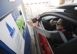 Una conductora paga el peaje en la Autopista del Huerna (AP-66)