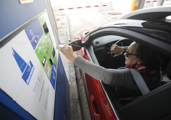 Una conductora paga el peaje en la Autopista del Huerna (AP-66)