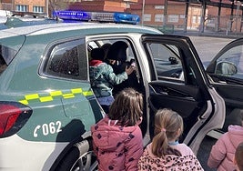 Los niños suben en un coche patrulla de la Guardia Civil