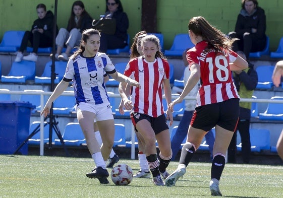 Ávila controla el balón ante dos jugadoras del Athletic B en La Toba.