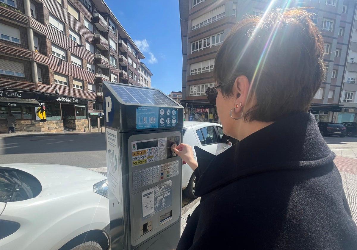 Una usuaria saca un tique de la zona azul en Pola de Siero.