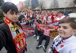 Los aficionados y representantes de las peñas del Sporting, junto a la estatua de Quini.