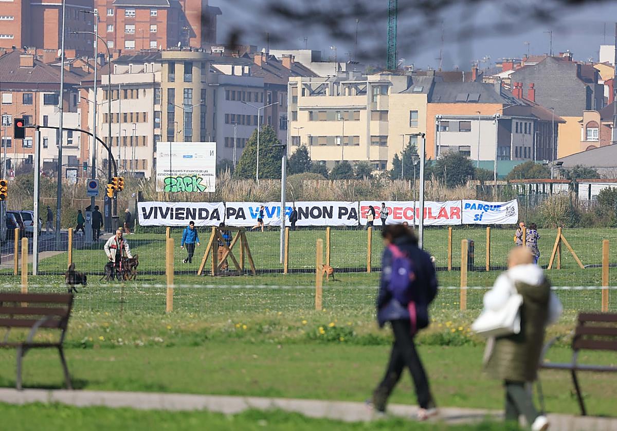Una enorme pancarta colocada en las vallas del 'solarón' de Gijón por SOS Vivienda Asturies reclama dedicar a parque los terrenos del plan de vías.