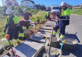 El alumnado reparando el tramo de acera en el acceso a El Llagarón, Candás