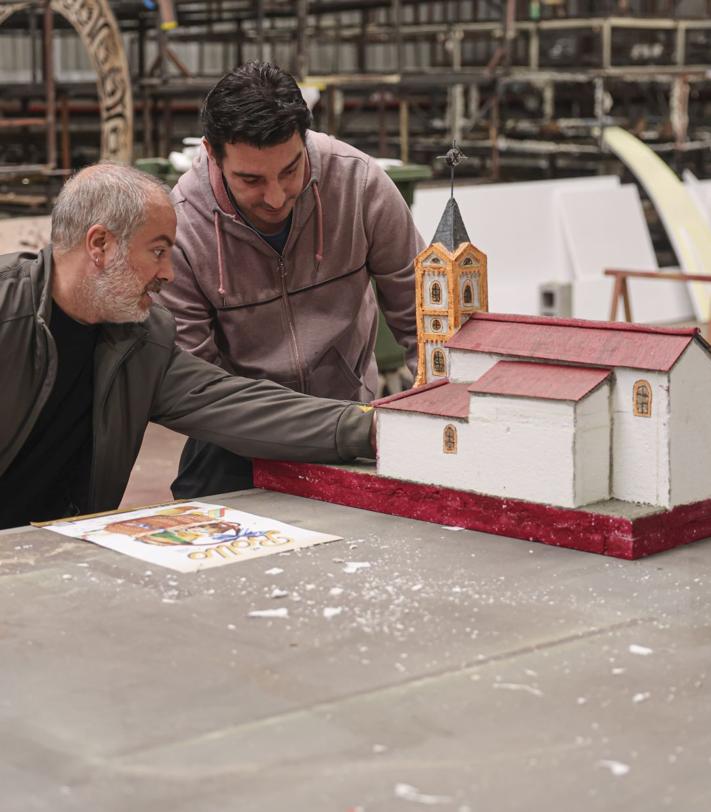 Imagen secundaria 2 - A la izquierda, Esther Cuesta conversa con sus compañeros sobre el trabajo de la carroza. A la derecha, hacen un repaso a la maqueta para que la carroza sea lo más igual posible.