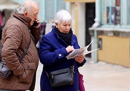 Una pareja se hace una foto ante la catedral de Oviedo.