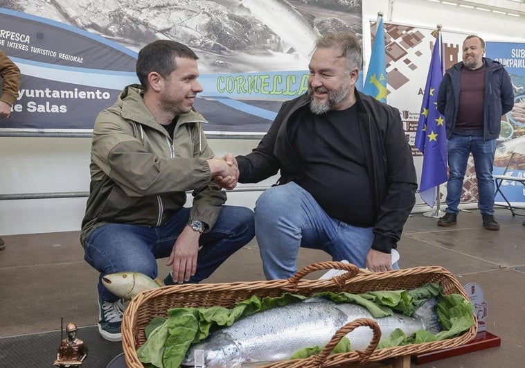 Javier Bueno, el pescador sacó el Campanu, estrecha la mano a Pedro Caramés, que ganó la subasta y se llevará el ejemplar al restaurante La Finca de Oviedo.