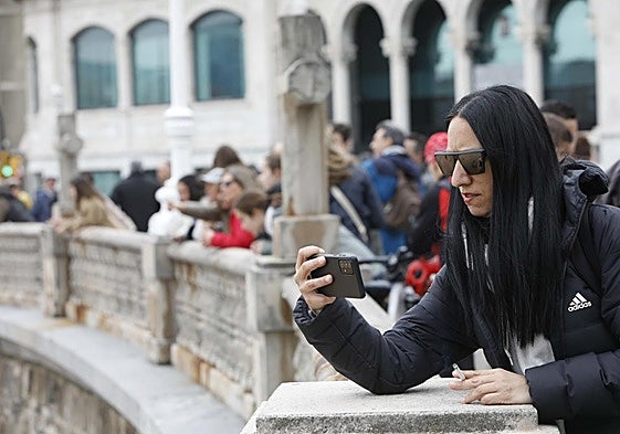 Turistas haciendo fotos en el paseo marítimo de Gijón esta Semana Santa.