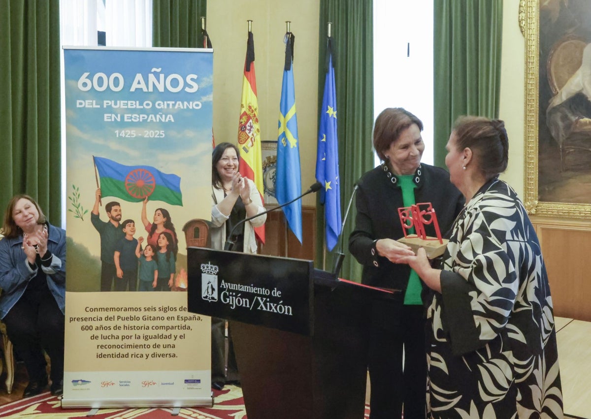 Imagen secundaria 1 - Adela Gabarri, emocionada, en el homenaje al pueblo gitano. Arriba, los asistentes posando en la escalera del Ayuntamiento de Gijón y la alcaldesa entregándole el símbolo de 'Las Letronas'.