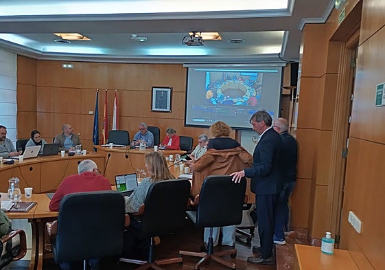 Inés García, de pie a punto de sentarse, junto al portavoz municipal del PP de Carreño.