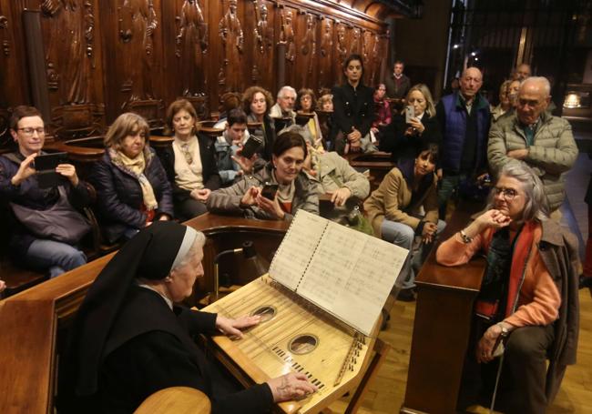 Una monja toca la cítara en San Pelayo ante el grupo de asistentes.