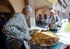 Valdés sirve una ración de paella a una vecina.