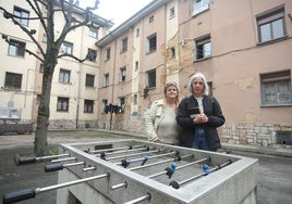 Noelia García y Almudena Pando, de la asociación Nuevo Ventanielles, ante un edificio con importantes desconchones que ha quedado fuera de la primera fase de obras.