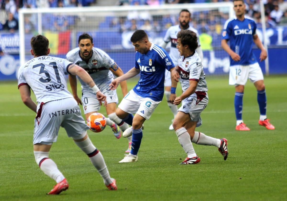 El jugador del Real Oviedo Portillo protege el balón, rodeado de jugadores del Levante.
