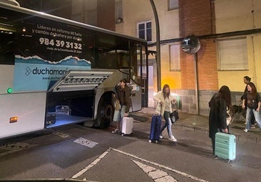 Los pasajeros salen del autobús y recogen las maletas tras el atasco del conductor.
