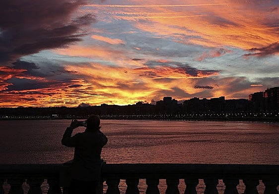 Una mujer fotografía el amanecer desde este destino asturiano.