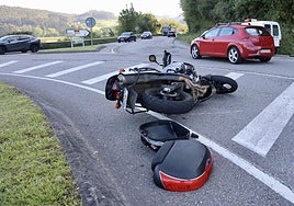La moto accidentada, tumbada sobre la carretera.