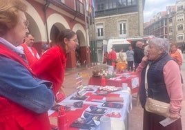 Voluntarios de la asamblea de Cruz Roja de Langreo informando a sus vecinos de sus proyectos para combatir la soledad no deseada.