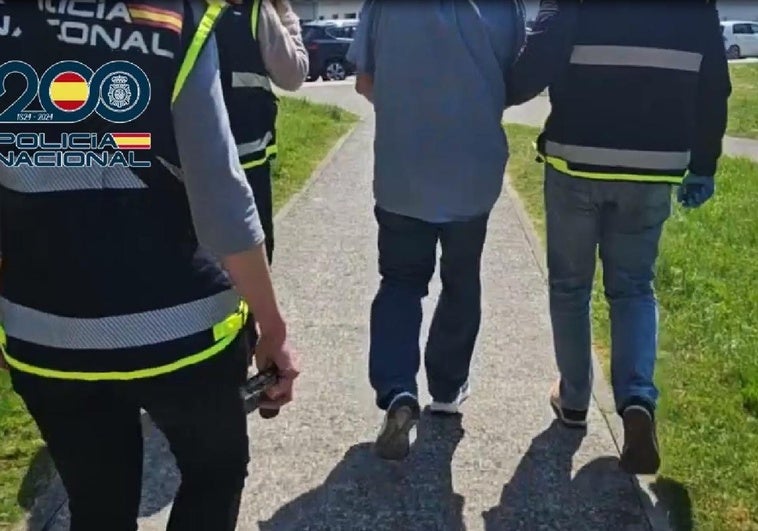 El detenido, flanquedo por policías nacionales.