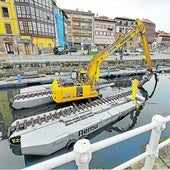 La escavadora anfibia, dotada con una bomba de succión, trabajando en el dragado del puerto de Llanes.