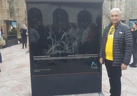 El ganador absoluto del Memorial María Luisa posa con su fotografía expuesta en Infiesto.