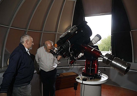 Santiago Izquierdo, presidente de la Sociedad Astronómica Asturias Omega, y Santiago Gándara, presidente del Observatorio de Monte Deva, que celebra este año su 30 aniversario, mirando por el telescopio.