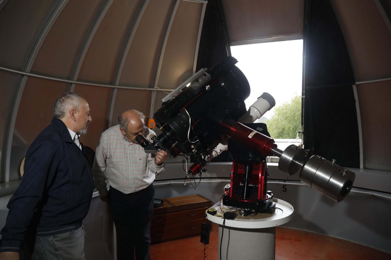 Santiago Izquierdo, presidente de la Sociedad Astronómica Asturias Omega, y Santiago Gándara, presidente del Observatorio de Monte Deva, que celebra este año su 30 aniversario, mirando por el telescopio.